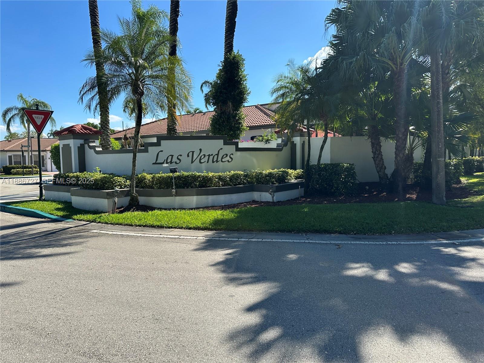15875 Southwest 3rd Street, Unit 101 Pembroke Pines, FL 33027 - Photo 28 of 32 front view of a house with a yard and potted plants