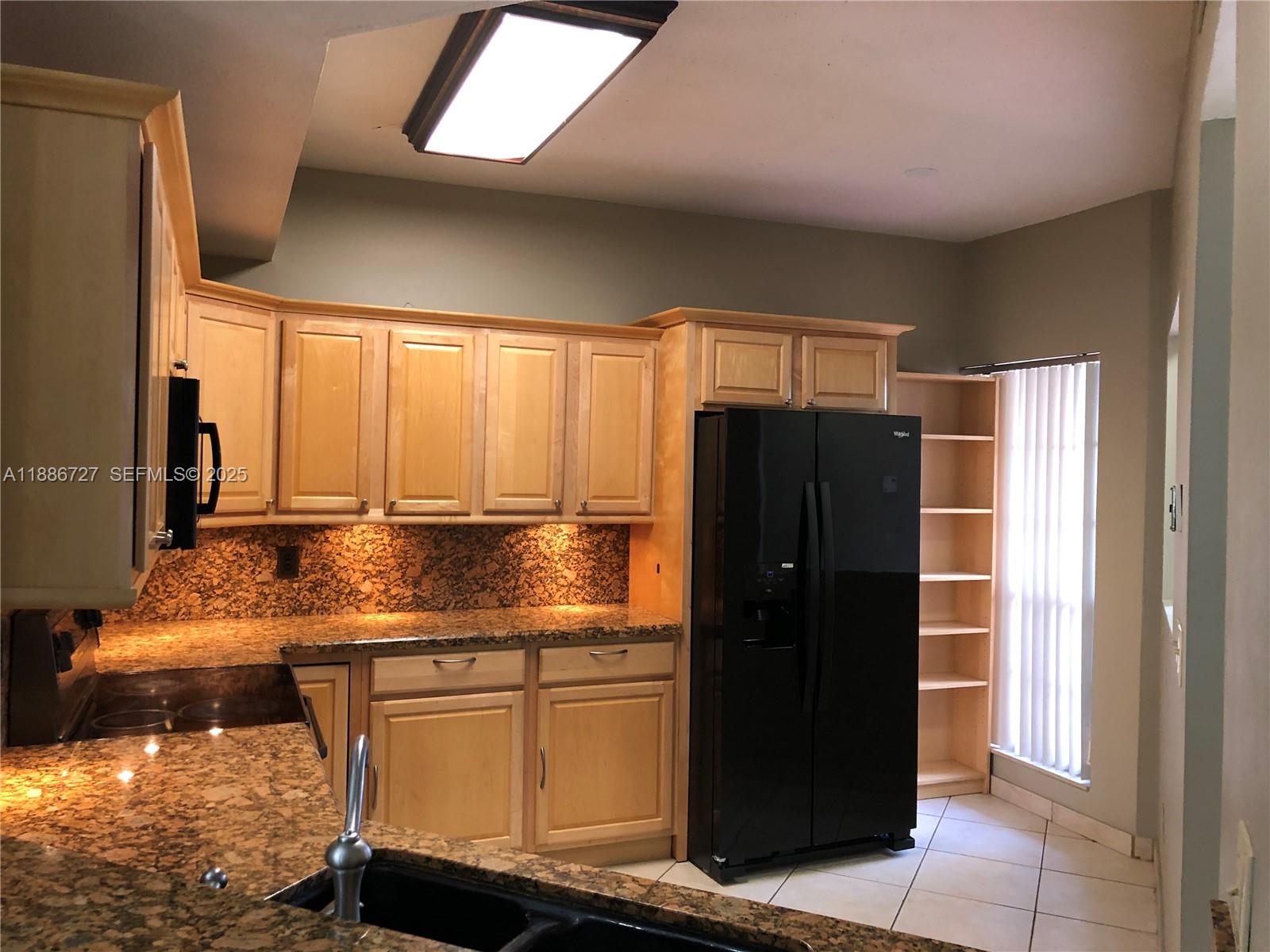 15875 Southwest 3rd Street, Unit 101 Pembroke Pines, FL 33027 - Photo 6 of 32 a kitchen with stainless steel appliances granite countertop a refrigerator and a stove