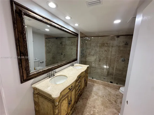 a bathroom with a sink mirror and a shower