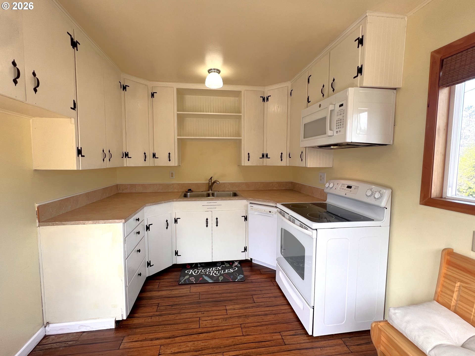 1092 Lewis Street North Bend, OR 97459 - Photo 14 of 43 a kitchen with granite countertop white cabinets and white appliances