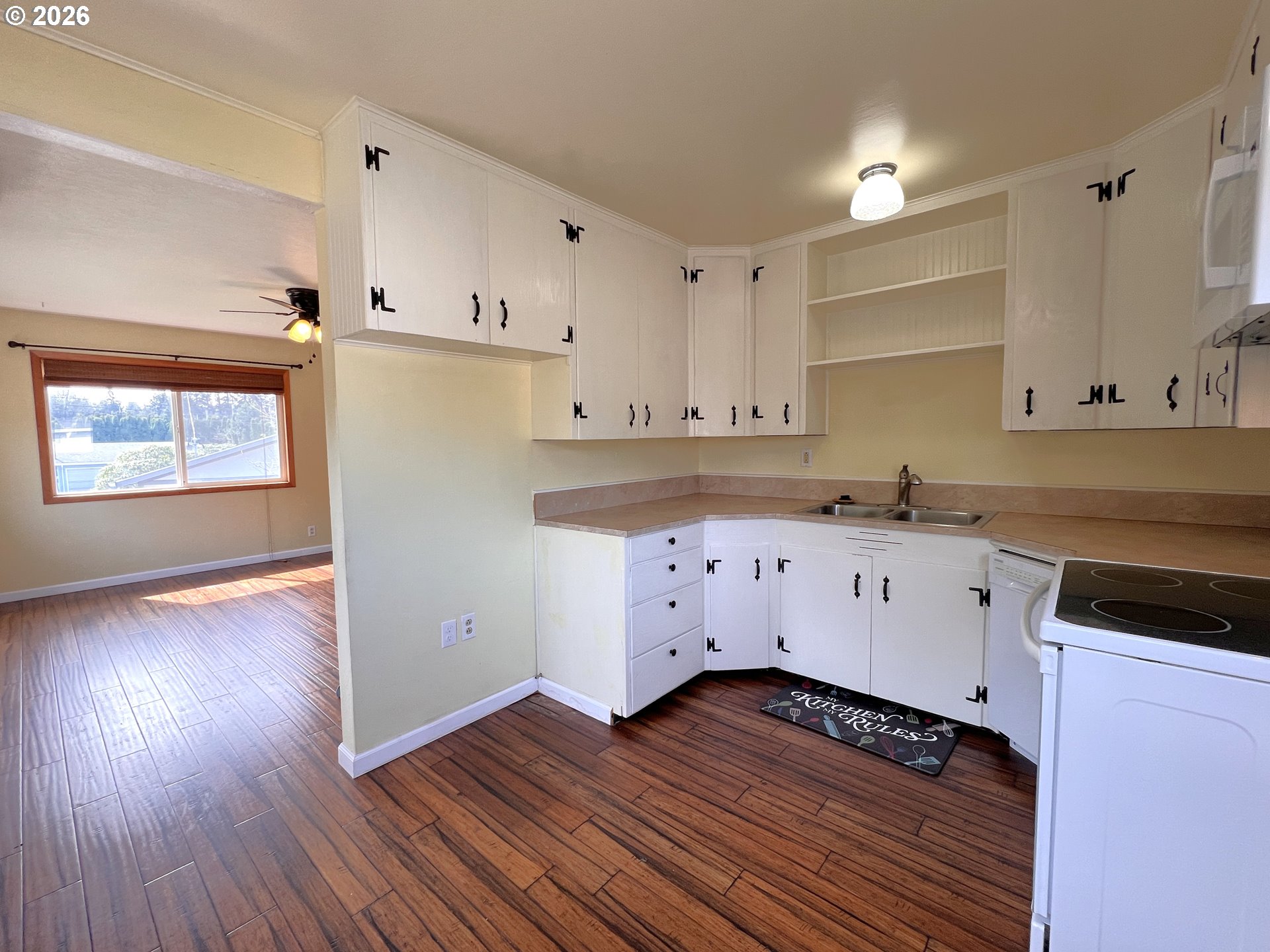 1092 Lewis Street North Bend, OR 97459 - Photo 15 of 43 a kitchen with wooden floors and white cabinets