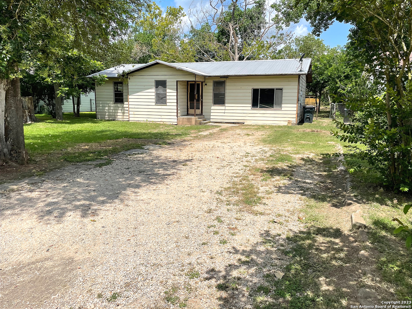 a front view of house with yard and trees around