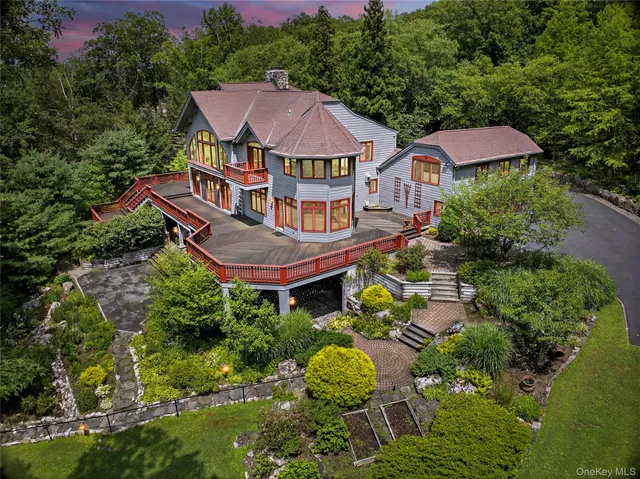 an aerial view of a house with swimming pool and trees