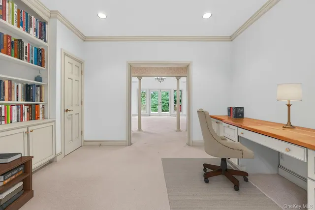 a view of a workspace with furniture and a window