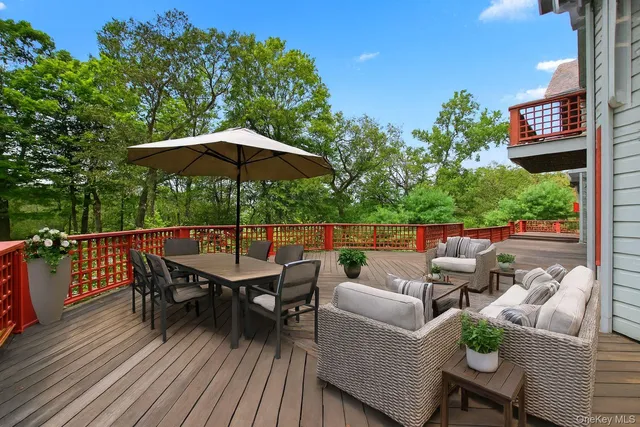 a balcony with wooden floor table and chairs