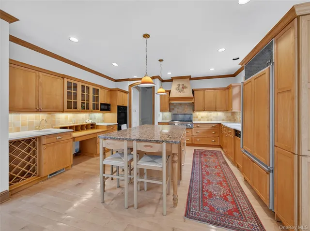 a kitchen with stainless steel appliances kitchen island granite countertop a table chairs sink and cabinets