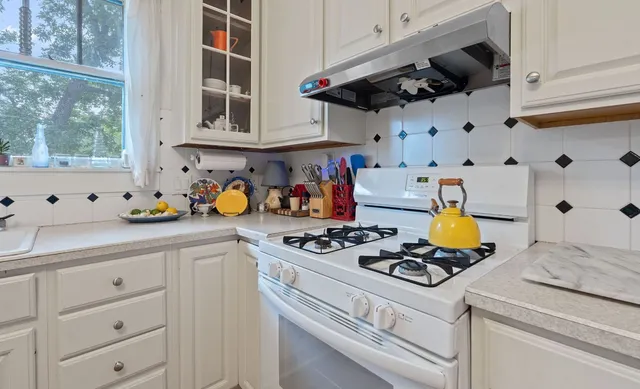 a kitchen with stainless steel appliances granite countertop a sink a stove and a cabinets
