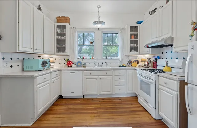 a kitchen with cabinets appliances and a window