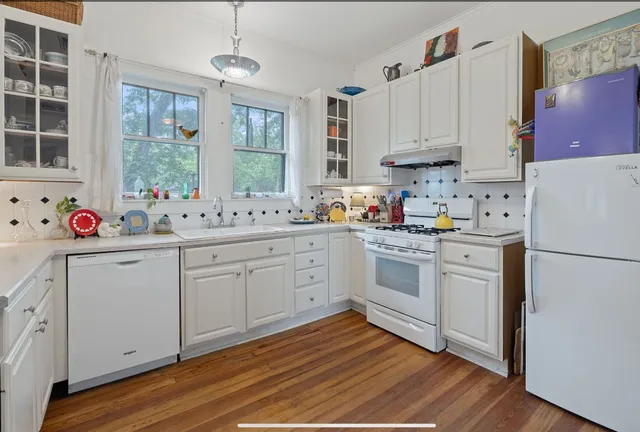 a kitchen with white cabinets sink and white appliances