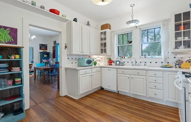 a kitchen with cabinets window and stainless steel appliances