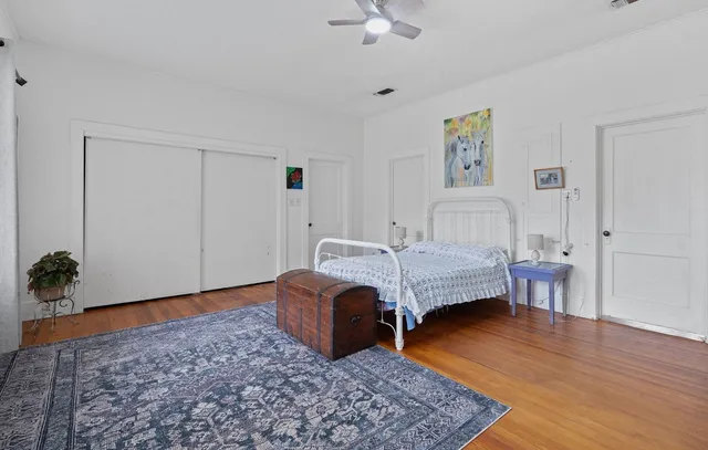 a bedroom with a bed and wooden floor