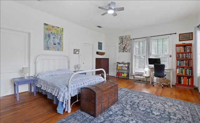 a bedroom with a bed a table and bookshelf