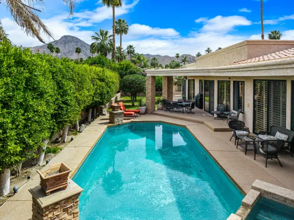 a view of a house with swimming pool and sitting area