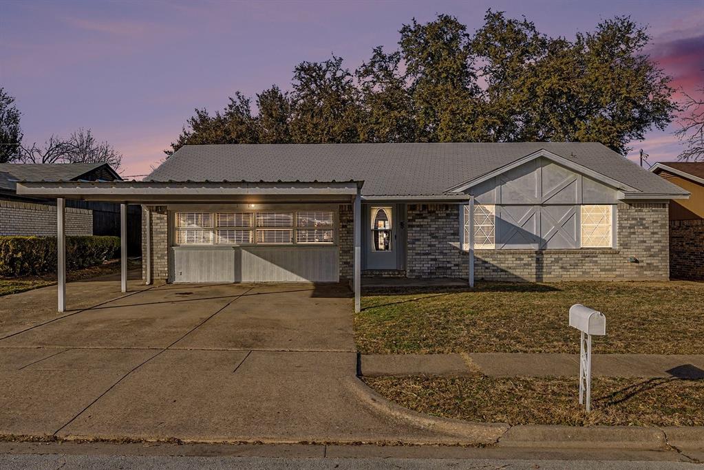 View of front of house featuring brick siding, concrete driveway, and a front yard