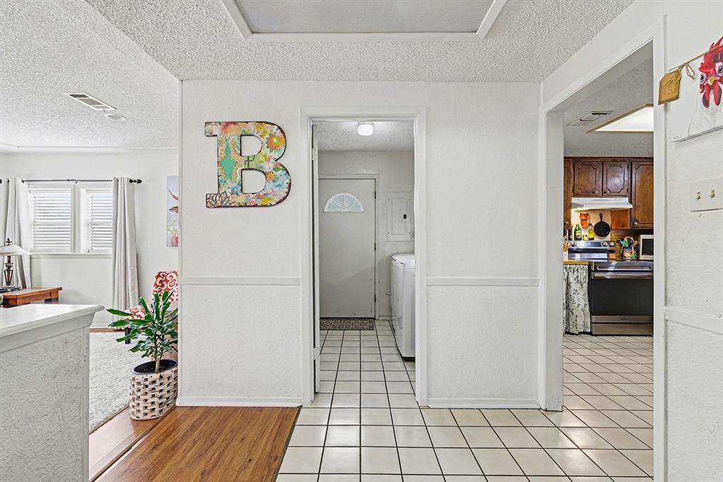 6013 Robin Drive Watauga, TX 76148 - Photo 11 of 30 Corridor with a textured ceiling and baseboards