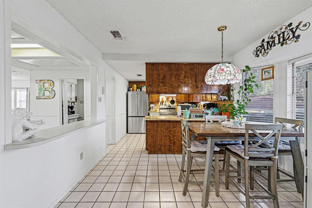 6013 Robin Drive Watauga, TX 76148 - Photo 12 of 30 Dining room featuring a textured ceiling and light tile patterned floors