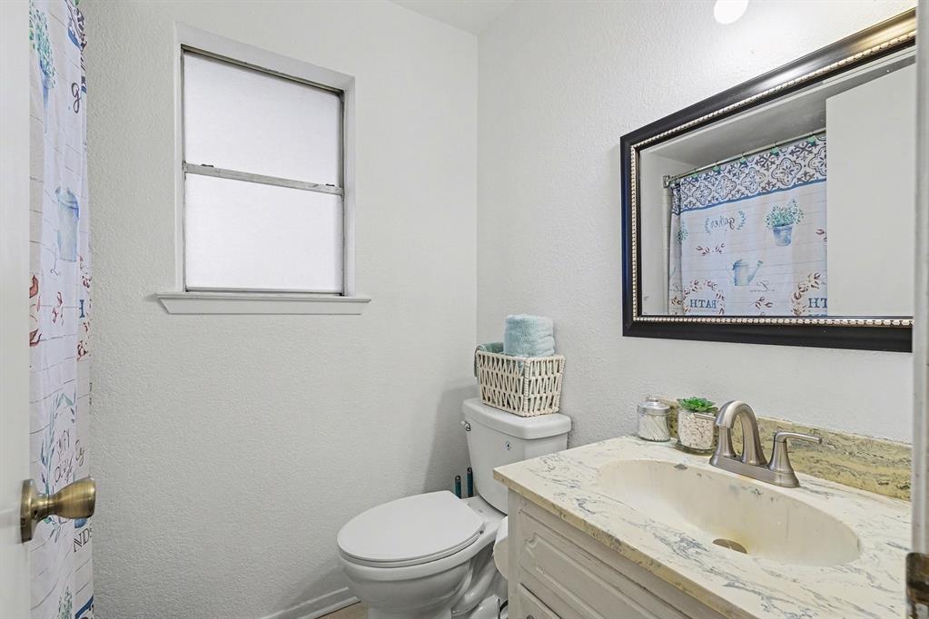 6013 Robin Drive Watauga, TX 76148 - Photo 17 of 30 Bathroom featuring a textured wall, a shower with shower curtain, and vanity