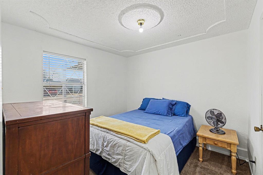 6013 Robin Drive Watauga, TX 76148 - Photo 24 of 30 Carpeted bedroom featuring a textured ceiling and baseboards