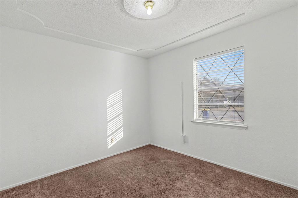 6013 Robin Drive Watauga, TX 76148 - Photo 25 of 30 Empty room featuring dark carpet and a textured ceiling