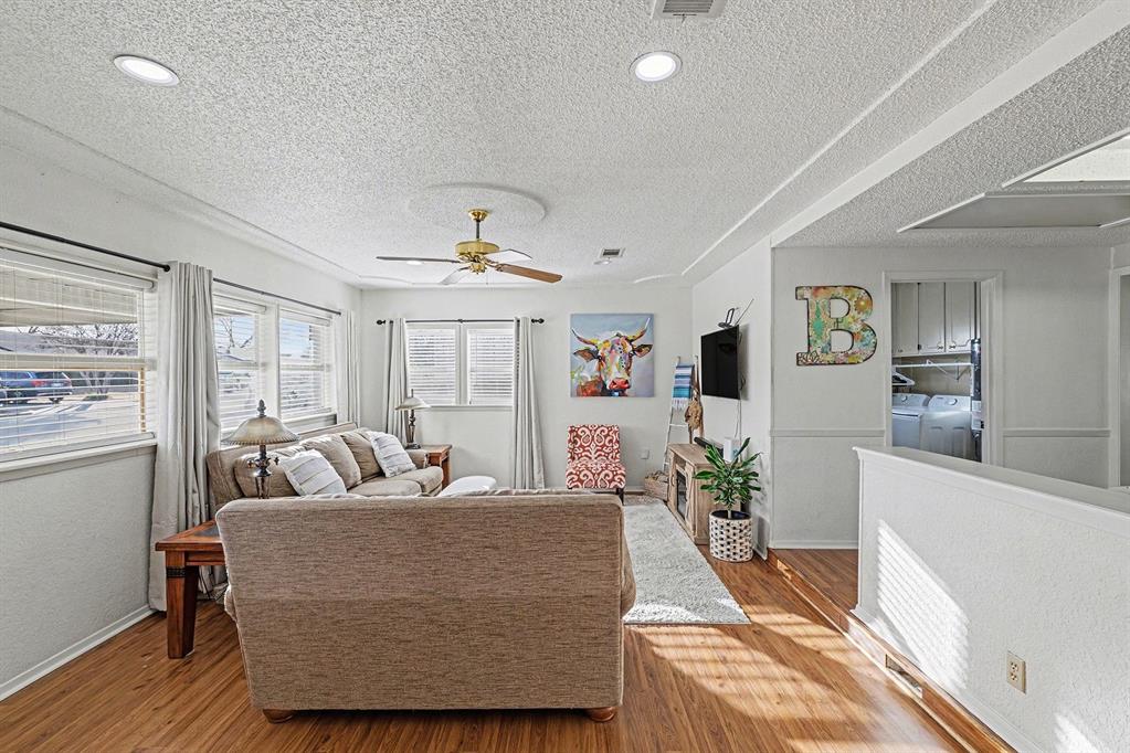 6013 Robin Drive Watauga, TX 76148 - Photo 6 of 30 Living room featuring wood finished floors, a textured ceiling, ceiling fan, and independent washer and dryer