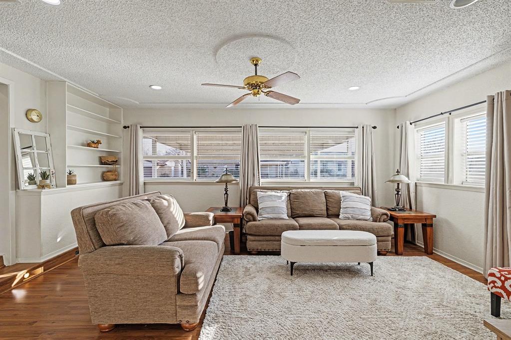 6013 Robin Drive Watauga, TX 76148 - Photo 8 of 30 Living room with ceiling fan, wood finished floors, a textured ceiling, healthy amount of natural light, and built in shelves