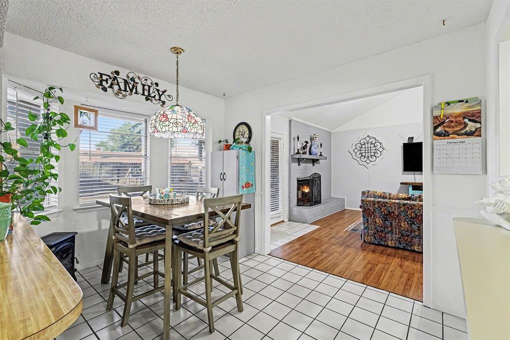6013 Robin Drive Watauga, TX 76148 - Photo 10 of 30 Dining room featuring light tile patterned flooring and a fireplace