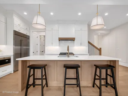 a kitchen with granite countertop a table chairs refrigerator and microwave