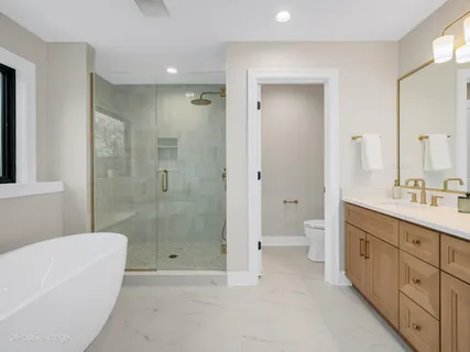 a bathroom with a double vanity sink toilet and shower