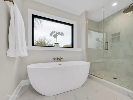 a white bath tub sitting next to a white shower and vanity