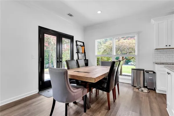 a kitchen with kitchen island a dining table and chairs