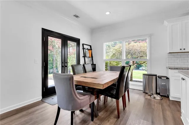 a kitchen with kitchen island a dining table and chairs