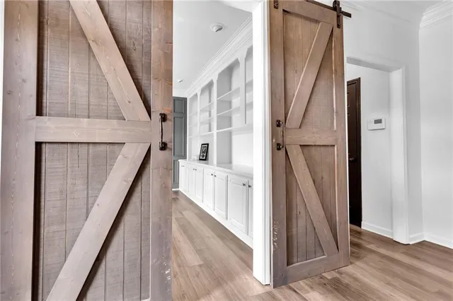 a hallway with white cabinets and wooden floor