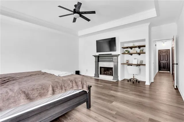 a spacious bedroom with a bed and a large window with wooden floor