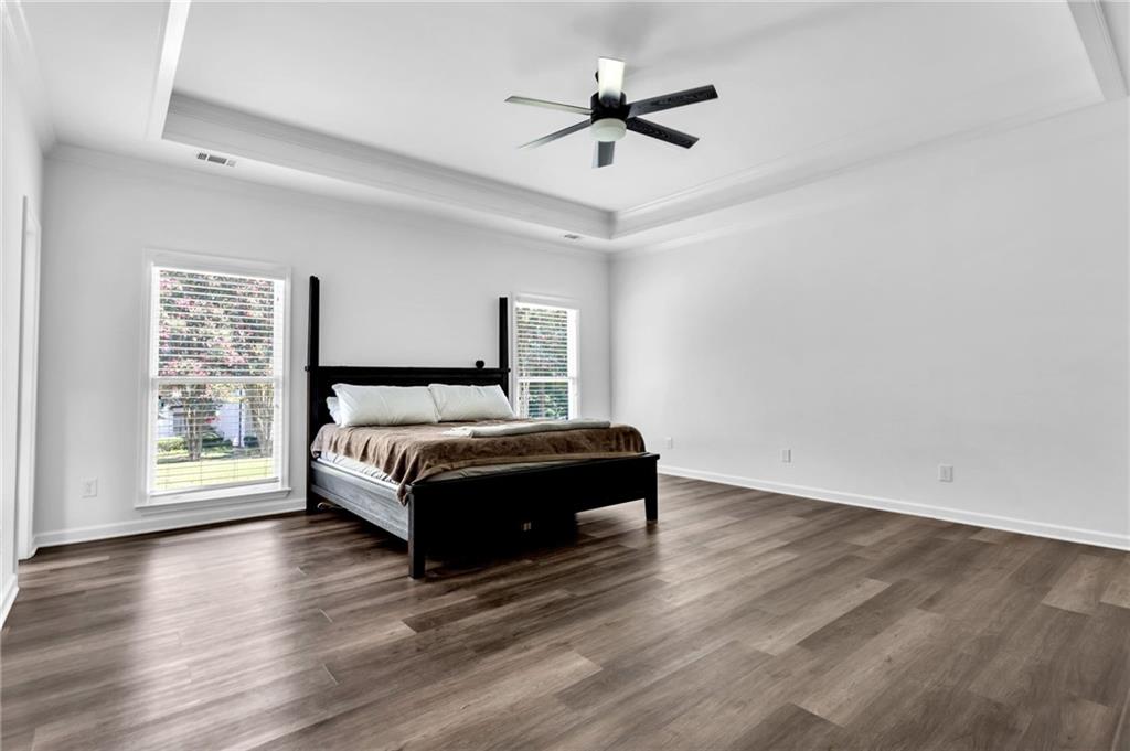 145 Springfield Creek Road Alpharetta, GA 30004 - Photo 17 of 27 a spacious bedroom with a bed and a large window with wooden floor