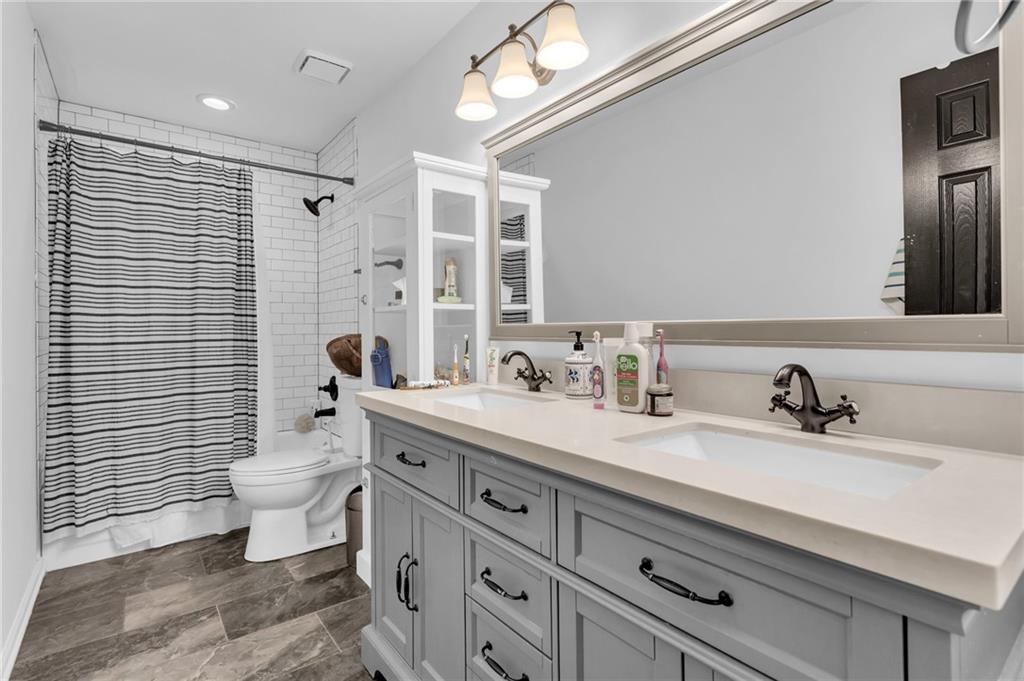 145 Springfield Creek Road Alpharetta, GA 30004 - Photo 24 of 27 a bathroom with a double vanity sink toilet and shower