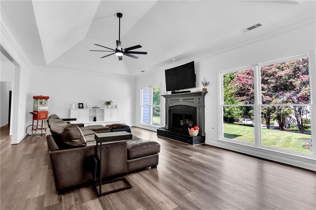 145 Springfield Creek Road Alpharetta, GA 30004 - Photo 5 of 27 a living room with furniture a flat screen tv and a fireplace