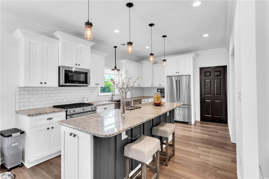 145 Springfield Creek Road Alpharetta, GA 30004 - Photo 7 of 27 a kitchen with appliances a sink cabinets and wooden floor