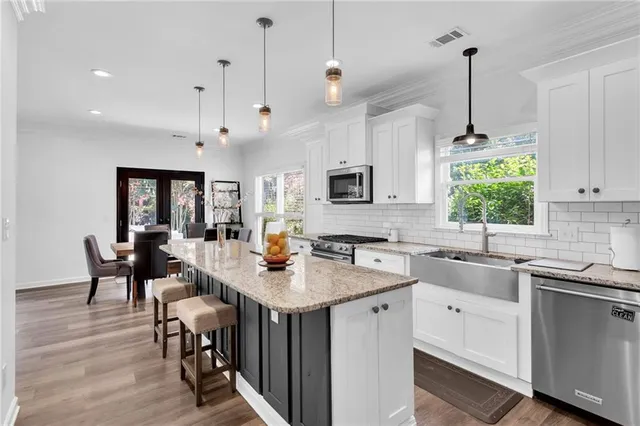 a kitchen with stainless steel appliances granite countertop a refrigerator sink and cabinets