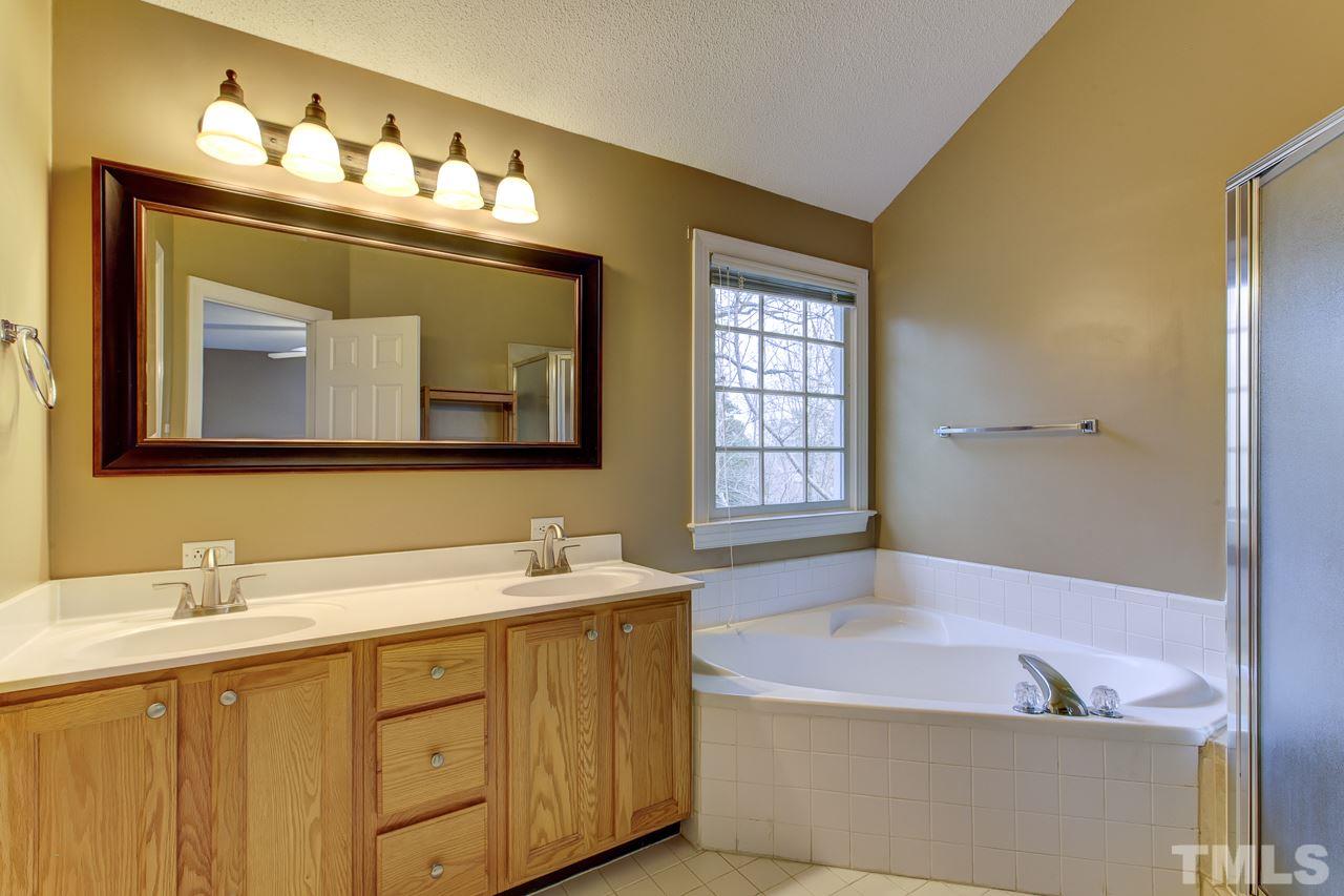 1432 Turner Farms Road Garner, NC 27529 - Photo 19 of 25 a bathroom with a tub sink and mirror