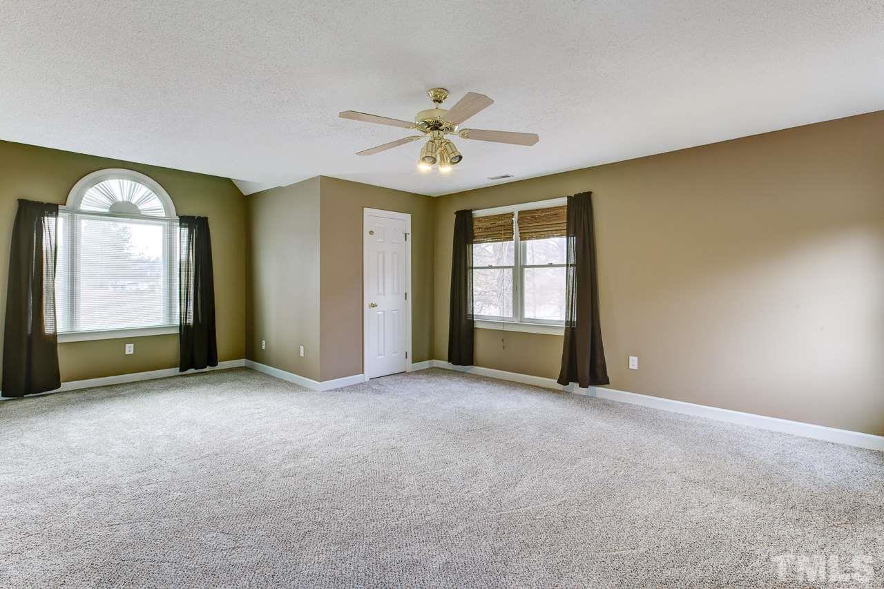 1432 Turner Farms Road Garner, NC 27529 - Photo 23 of 25 an empty room with windows and ceiling fan