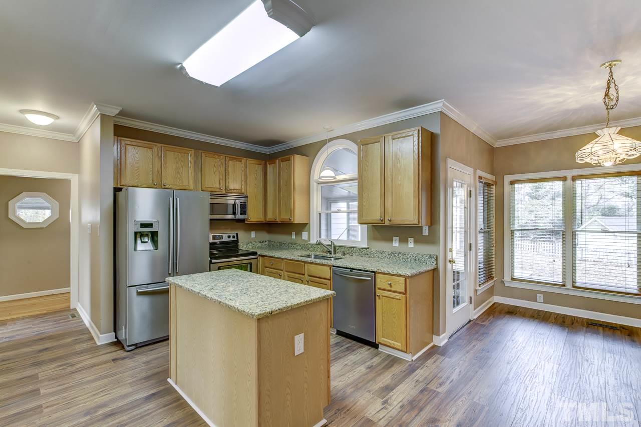 1432 Turner Farms Road Garner, NC 27529 - Photo 9 of 25 a kitchen with refrigerator a stove and cabinets