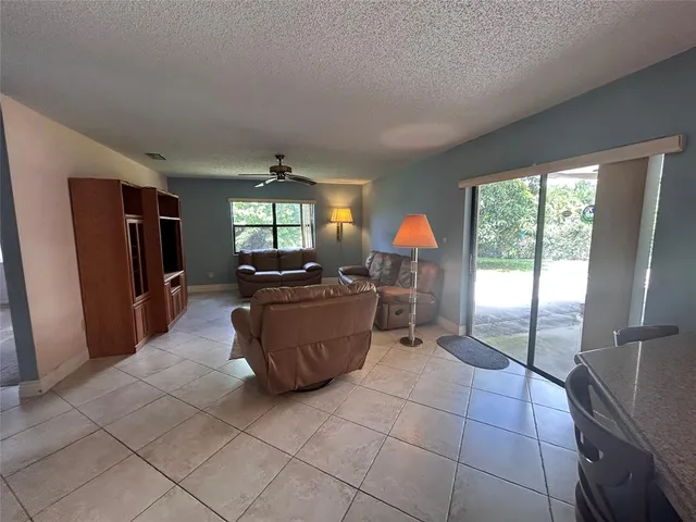 a living room with furniture a flat screen tv and a large window