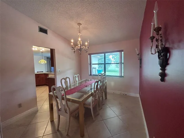 a view of a dining room with furniture and chandelier