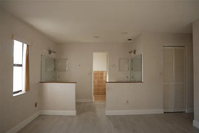 an empty room with windows and closet