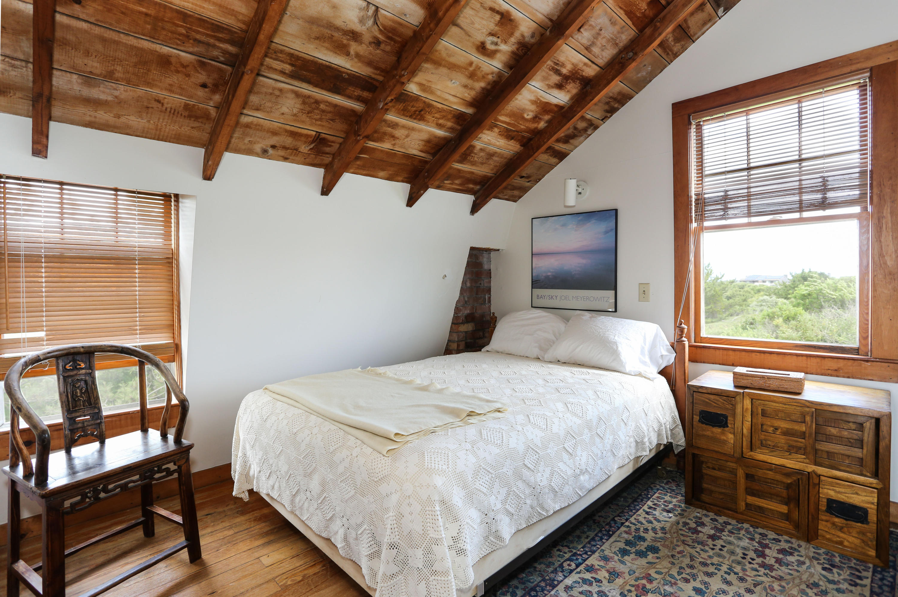12 Pilgrims Path Truro, MA 02666 - Photo 16 of 25 a bedroom with a bed wooden floor and window