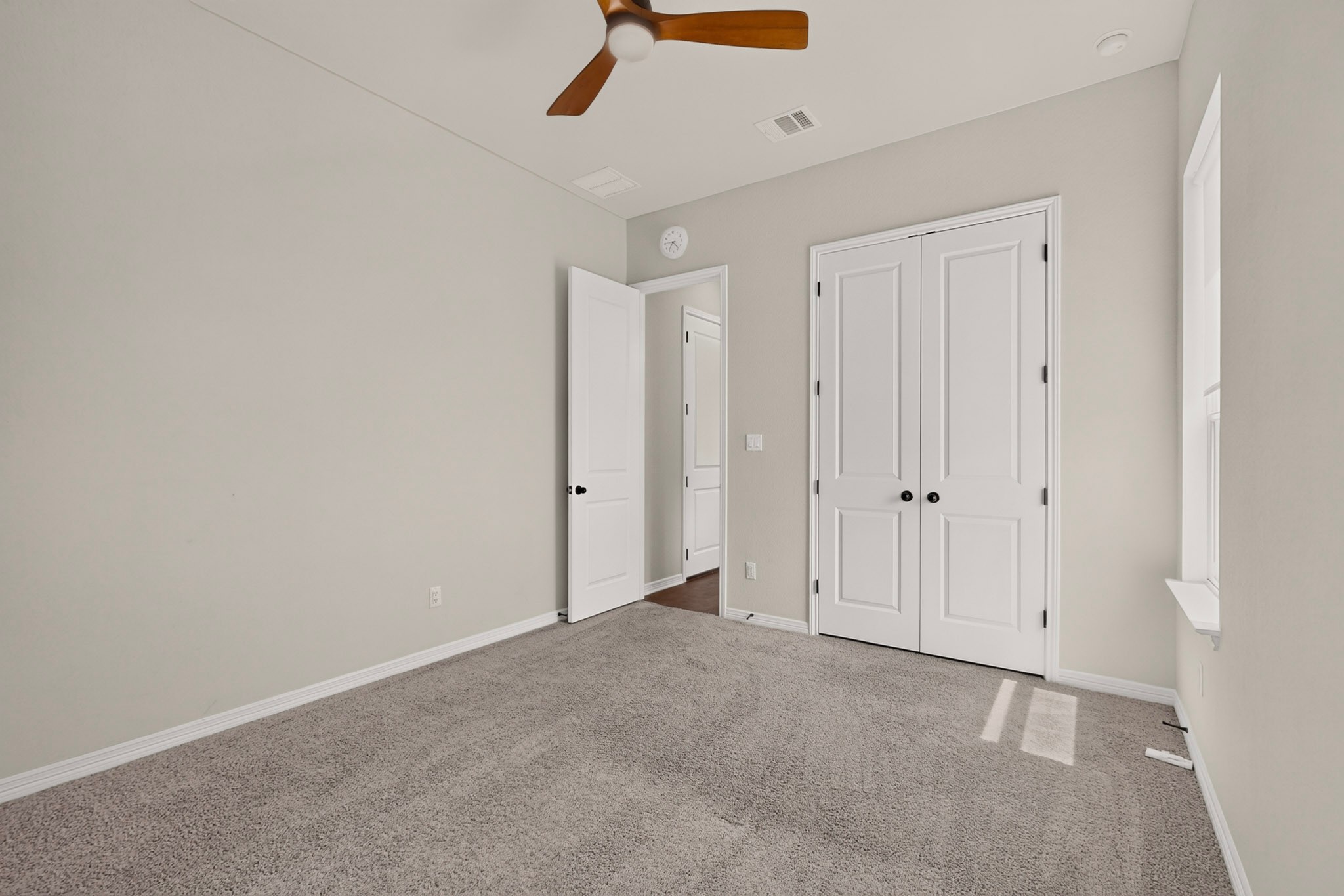 2433 La Mirada Street Leander, TX 78641 - Photo 17 of 25 A well-lit bedroom offering a restful retreat with soft carpet and a convenient ceiling fan.