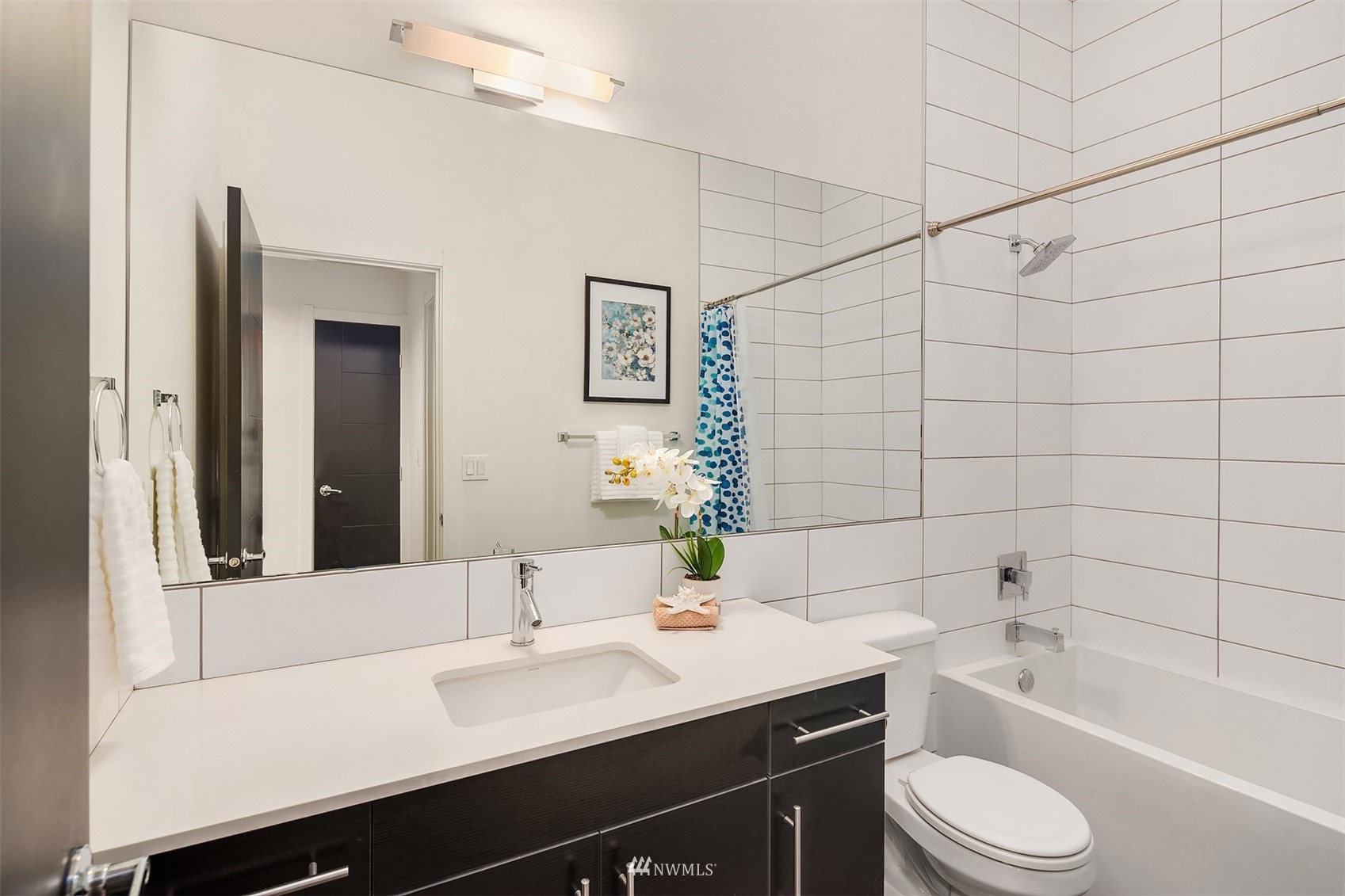 8000 Meridian Avenue North Seattle, WA 98103 - Photo 23 of 33 a bathroom with a granite countertop sink toilet a large mirror and shower