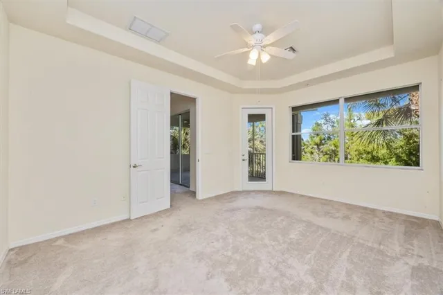 an empty room with windows chandelier fan and windows