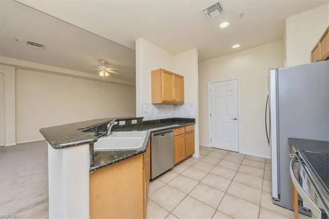 a kitchen with granite countertop a sink and a refrigerator