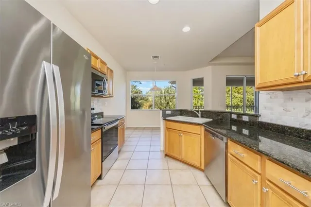 a kitchen with stainless steel appliances granite countertop a sink and a stove
